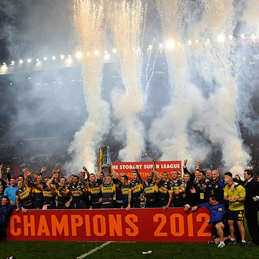 A photo of Leeds players celebrating as they lift the trophy at Old Trafford football stadium, Manchester, after the Rugby League Super League Final 2012