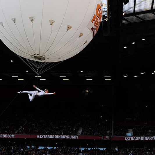 A photo of an aerial performer suspended from a large floating balloon at Old Trafford football stadium, Manchester, prior to the Rugby League Super League Final 2012